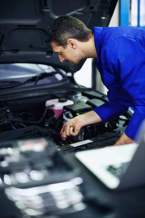 hereth insurance consulting - auto repair shop insurance - mechanic inspecting a car engine in a repair shop
